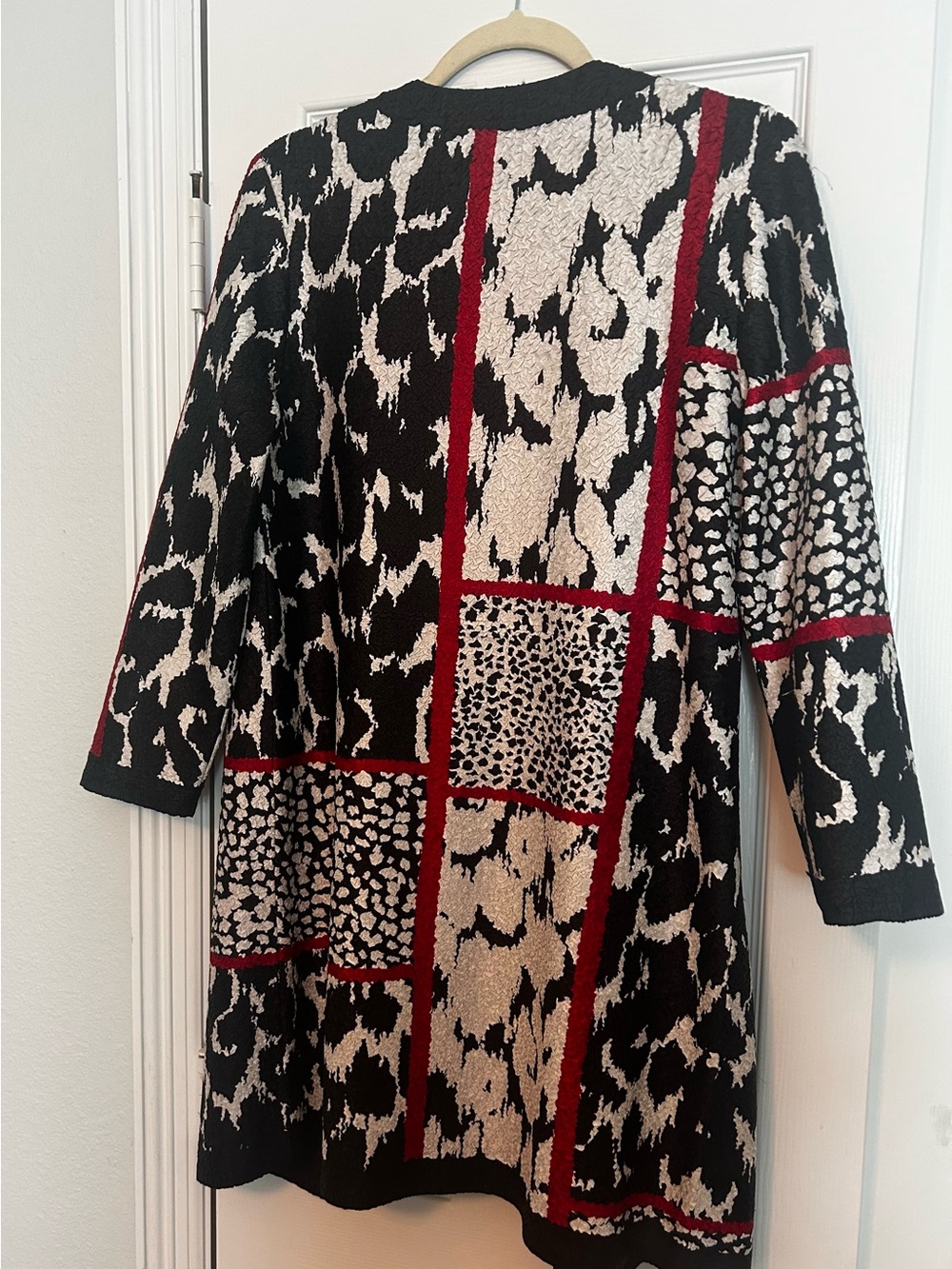 Long-Sleeve Black & Ivory Animal-Print Patchwork jacket with Red Trim.